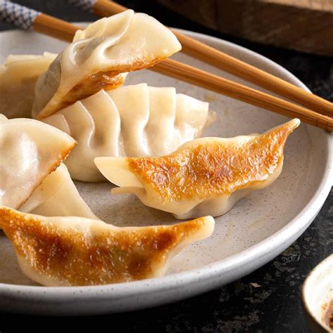 GYOZA meaning: 1. a Japanese food consisting of meat or vegetables wrapped in dough (= flour and water mixed…. Learn more.